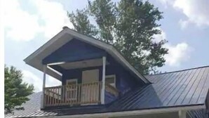 A two-story house with a balcony, a front porch, and a driveway. - Big Blue House Apt 1 (Pikeville)