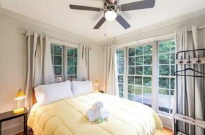 Relax in this serene bedroom with a large bed, ceiling fan, and two bedside tables with lamps.