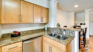 A kitchen with wooden cabinets, granite countertops, a stainless steel sink, and a dishwasher. - Walkable Location: Phoenix Apt w/ Pool Access! (Phoenix)