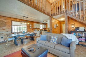 Cozy cabin-style living area with a comfortable sofa, dining table for four, and modern coffee table.