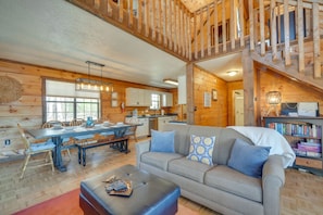 Cozy cabin-style living area with a comfortable sofa, dining table for four, and modern coffee table.