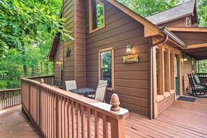 Relax on the Windsong deck, where a table and chairs invite dining and socializing amidst the forest surroundings.
