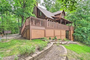 Escape to a serene forest retreat with a charming cabin featuring a spacious balcony and scenic views.
