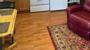 A compact kitchen with wooden cabinets, a white stove, and a refrigerator. - The   Nook (Pikeville)