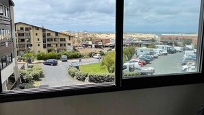 A balcony with a view of a marina and buildings. - Seignosse Ocean, beautiful apartment with SEA VIEW, close to the beach and town center, sleeps 4 (SEIGNOSSE)