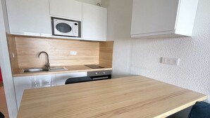 A compact kitchen with a wooden countertop, a built-in microwave, and white cabinets. - Seignosse Ocean, beautiful apartment with SEA VIEW, close to the beach and town center, sleeps 4 (SEIGNOSSE)