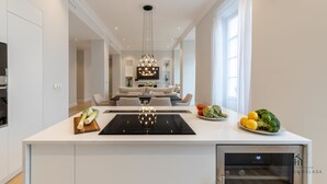 Een moderne keuken met een centraal eiland, een ingebouwde oven en een zithoek met een bank en tafel.