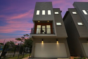A modern two-story house with a balcony and a garage.
