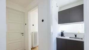 A modern kitchen with dark cabinets, a white countertop, and a built-in oven.