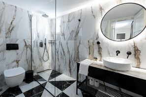 Features a sleek floor, oval mirror, and vessel sink with a black countertop.