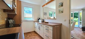 A compact kitchen with a window, a coffee maker, and a view of the outdoors.