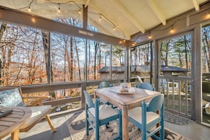 A cozy outdoor seating area with a table and chairs, overlooking a forested landscape. - Pet Friendly, Location Score 99, Fire Pit, Hiking, Fall Colors! (Newland)