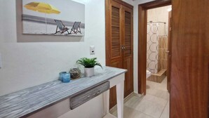 A bathroom with a shower, a towel rack, and a toilet. - Lovely Spacious Condo with Pool View, Close to Beaches and Shops! (Punta Cana)