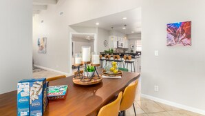 A spacious dining area with a wooden table, chairs, and a view into the kitchen. - Beautiful 2 Bedroom 2 Bath Scottsdale Townhome (Scottsdale)