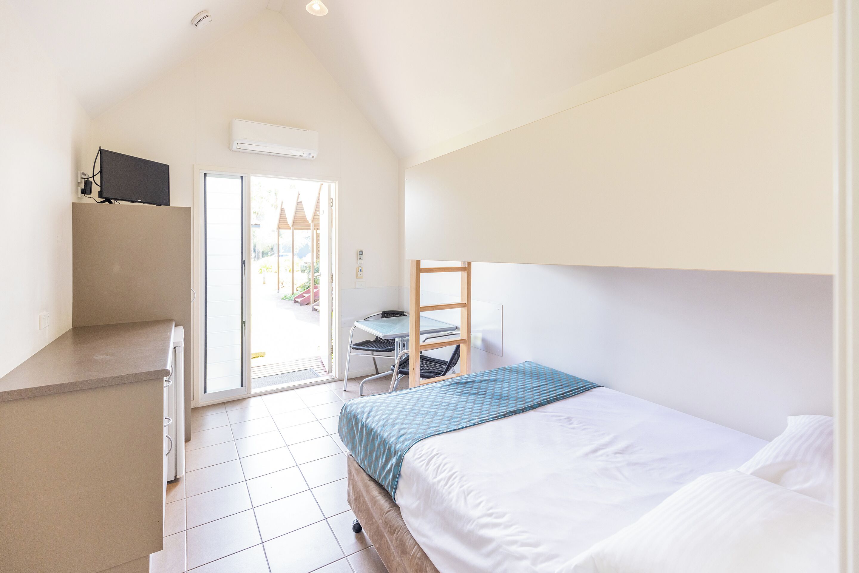 Un dormitorio con cama, escritorio y silla.