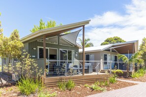 A modern building with a covered outdoor area, large windows, and a deck with seating. - NRMA Batemans Bay Holiday Park (Batehaven)