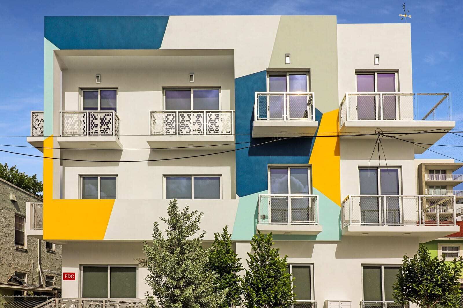 A multi-story building with balconies, large windows, and a mix of geometric patterns on the facade.