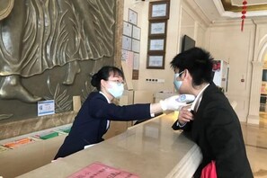 A reception desk with a receptionist and a guest. - Vienna Hotel Guangzhou Huadu Cultural Tourism City Shiling shop (Guangzhou)