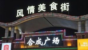 A building with illuminated signage reading "风情美食街" and "合成广场". - Vienna Hotel Guangzhou Huadu Cultural Tourism City Shiling shop (Guangzhou)