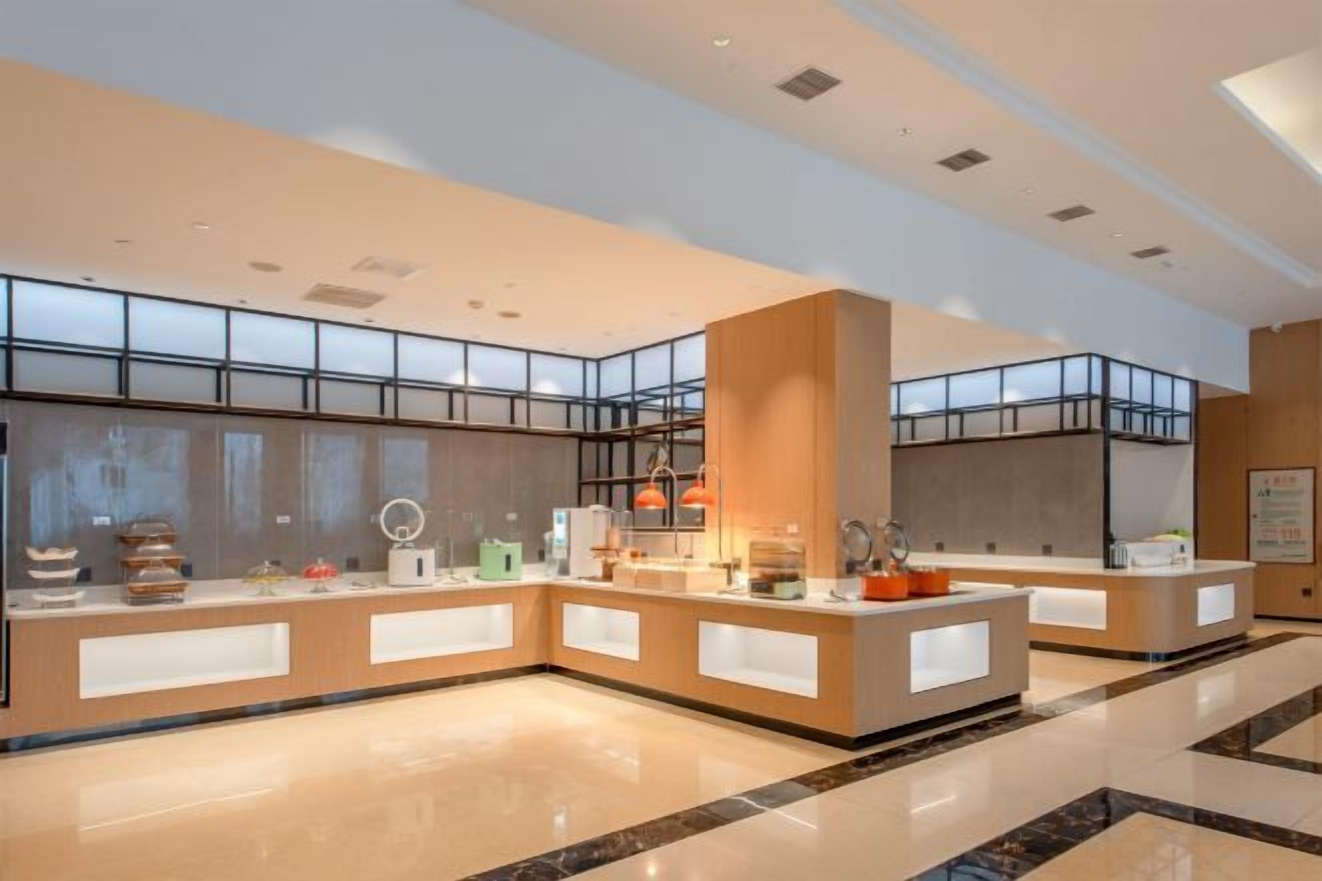A hotel lobby with a reception desk, a large window, and a modern design.