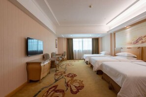 A hotel room with two beds, a desk, a chair, a TV, and a floral carpet. - Vienna Hotel Guangzhou Huadu Cultural Tourism City Shiling shop (Guangzhou)