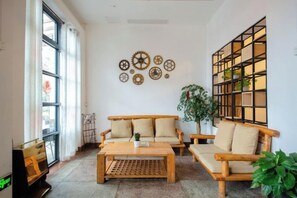 A living room with a sofa, a coffee table, and a bookshelf. - Chuanranli Hotel (Chongqing)