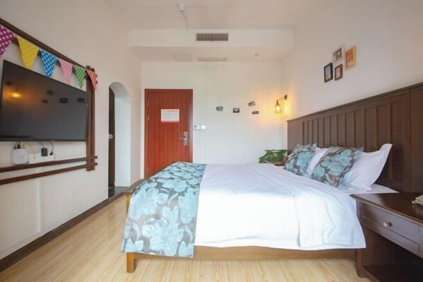 A hotel room with a bed, bedside table, wall-mounted TV, and a door with a sign. - Chuanranli Hotel (Chongqing)
