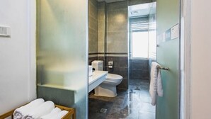 Kylpyhuone, jossa on wc, pesuallas ja pyyheteline.