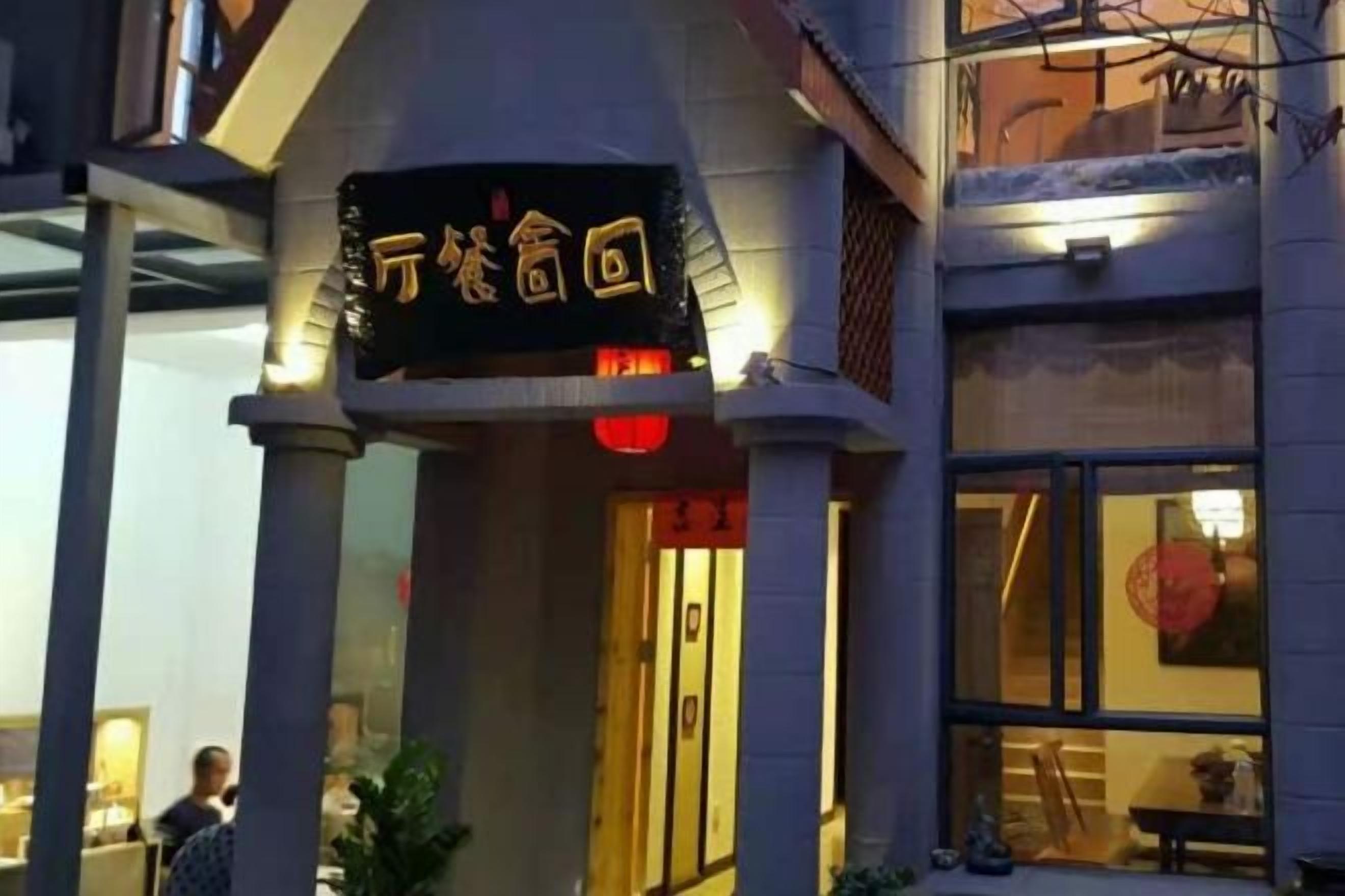 A building with a sign that reads '万家家回' and a window with a red decoration.