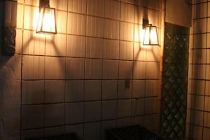 Eine Wand mit Fliesen und zwei Wandleuchten.