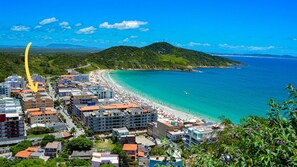 Une ville côtière dotée d’une plage, de bâtiments et d’un paysage vallonné.