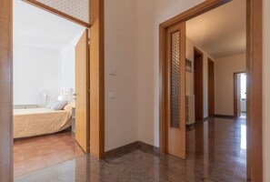 Relax in this serene space with a comfortable bed, bedside table, and wall-mounted fan.