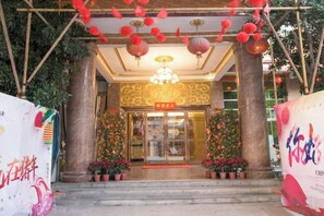 A hotel entrance with a grand staircase, a chandelier, and decorative lanterns. - Huayang Hotel (Puning)