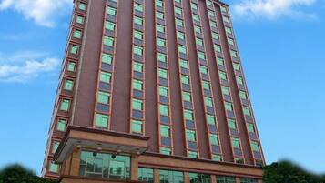 A tall building with a red facade and multiple windows.
