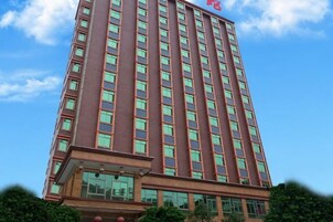 Un edificio alto con fachada roja y múltiples ventanas.