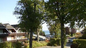 Un barrio residencial con casas, un coche y vistas al mar.