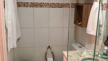 A bathroom with a toilet, a sink, and a shower area.