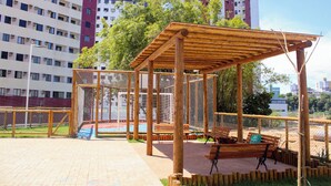 A wooden pavilion with benches, surrounded by a fence, in an urban park setting. - AxéHome | Charming Accommodation | 2 Bedrooms / 2 Bathrooms (Salvador)