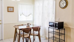 A small kitchen with a dining table, chairs, a microwave, and a shelf. - 2 BD Quiet Neighborhood with AC, Desk, Fast Wifi (Torrance)