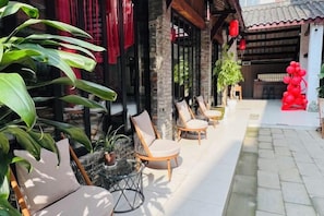 A courtyard with outdoor seating, potted plants, and traditional architecture. - Gongxiaoshe Inn (Luo Dai Ancient Town) (Chengdu)