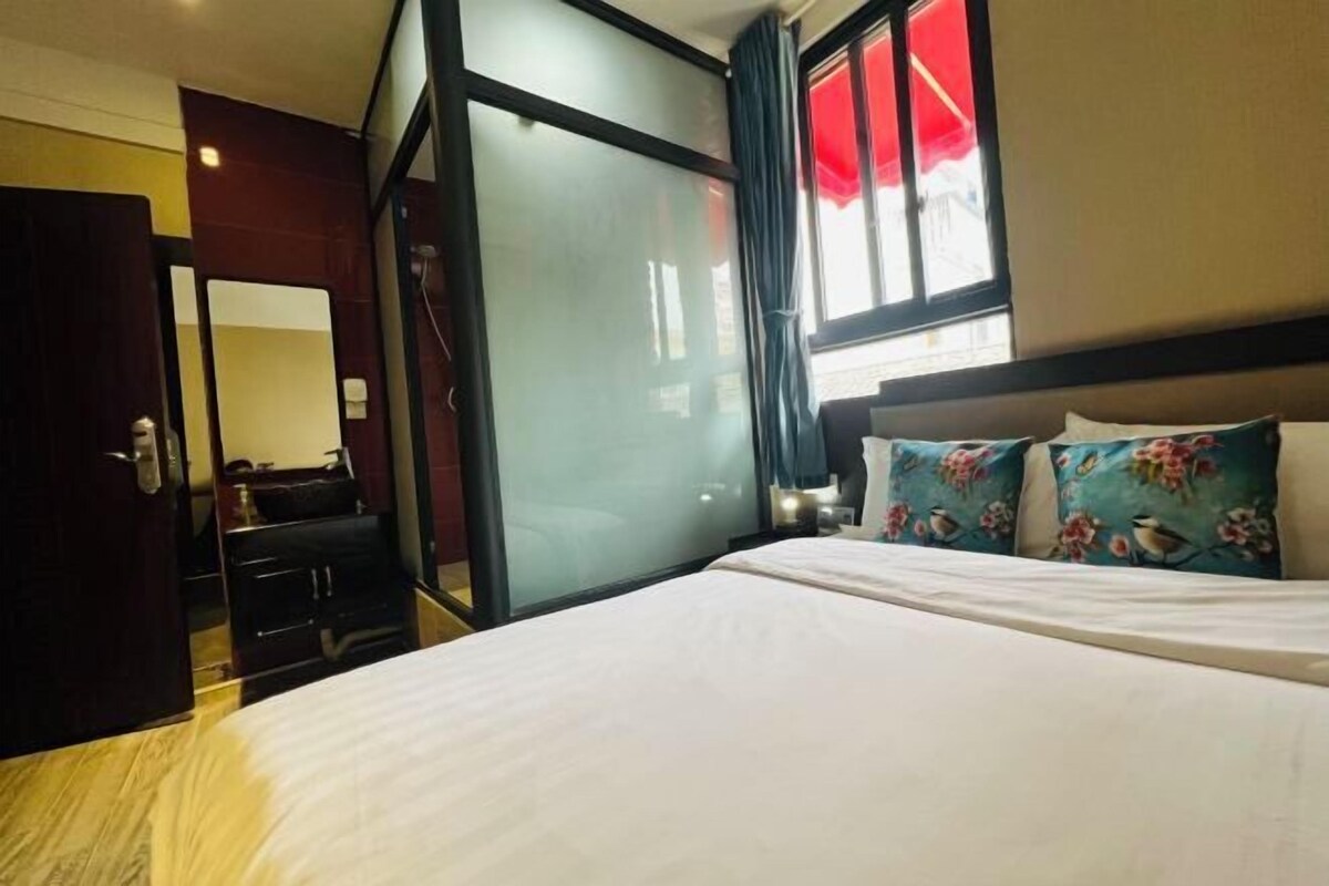 Ein Hotelzimmer mit Bett, Schreibtisch und einer Schiebetür.