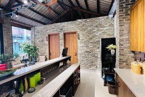 A kitchen with a stone wall, wooden cabinets, and a long counter. - Gongxiaoshe Inn (Luo Dai Ancient Town) (Chengdu)