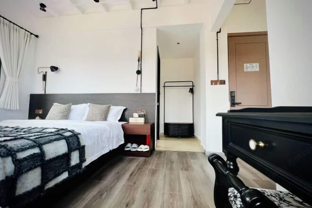 A modern bedroom with a bed, bedside table, lamp, and a wardrobe.