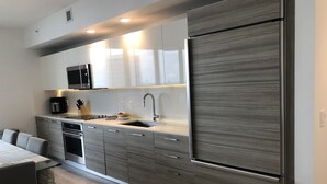 A modern kitchen with a large refrigerator, stainless steel appliances, and a sleek countertop.