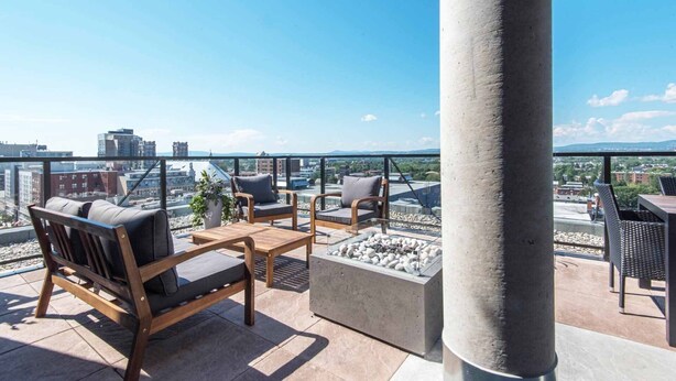 Une terrasse sur le toit avec des sièges extérieurs, un foyer et une vue sur la ville.