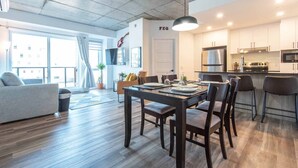 Un appartement moderne comprenant un coin repas, une cuisine et un espace de vie.