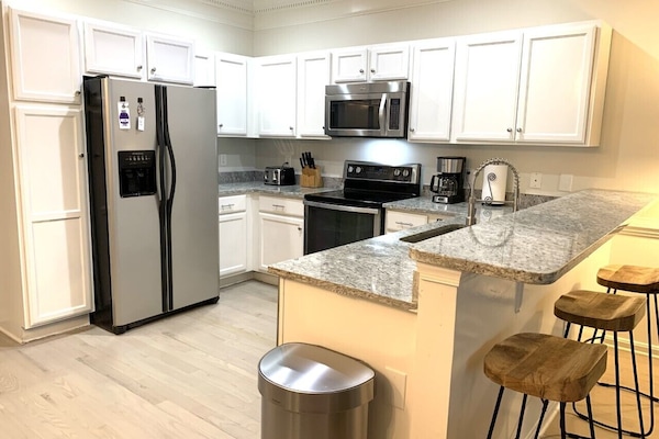 Kitchen with granite counter and seating for 3 at the breakfast bar.
