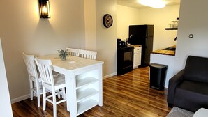 Un espace de vie compact comprenant un coin repas, une kitchenette et un coin salon.
