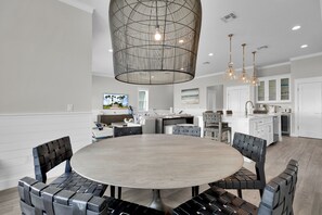 A modern kitchen with white cabinets, a large island, and pendant lighting.
