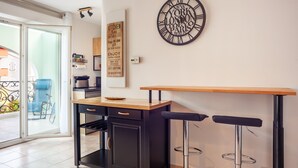 Una cocina moderna con encimera de madera, armarios negros y un taburete de bar.